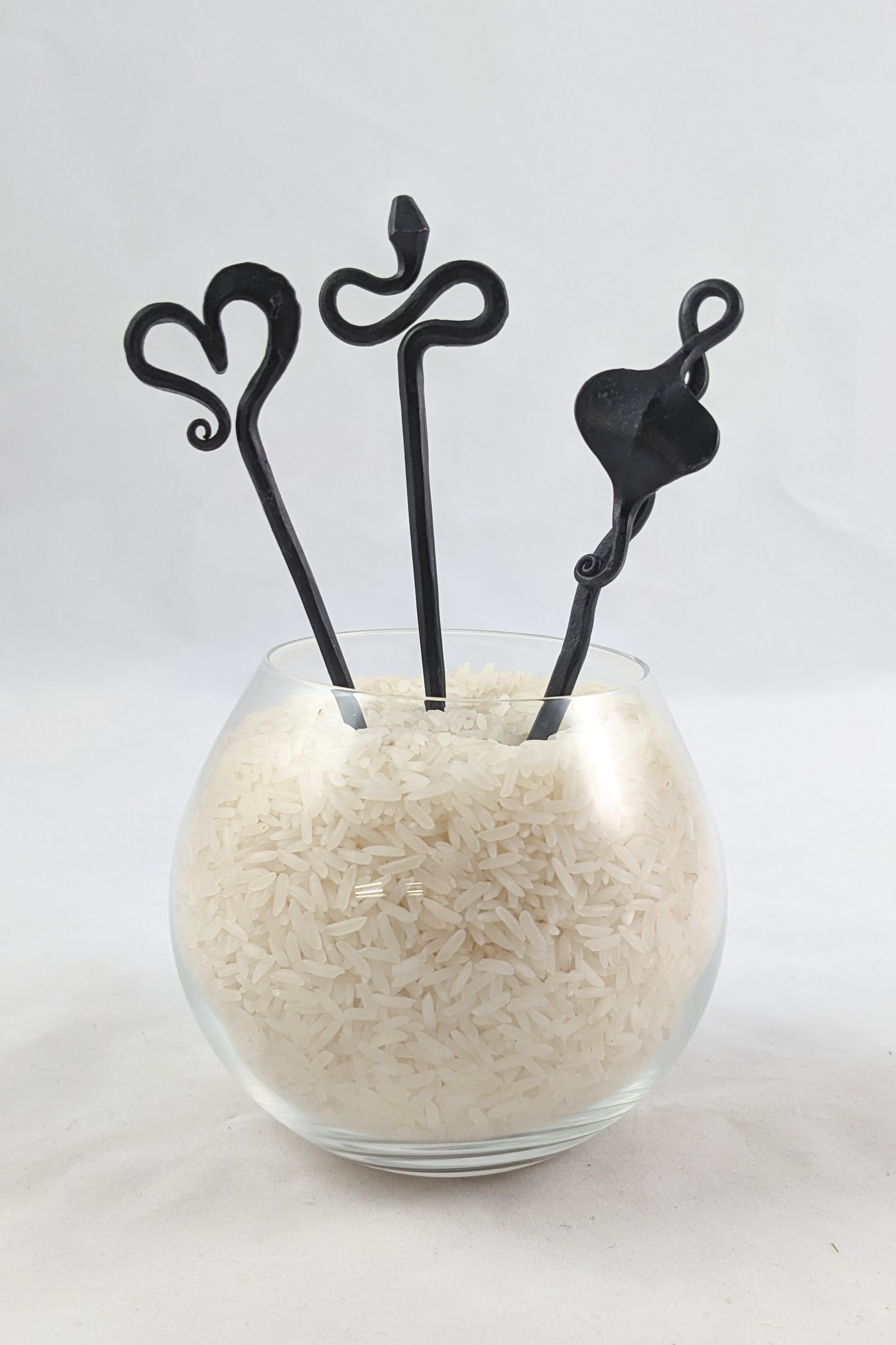 three hairpins in a clear container of rice