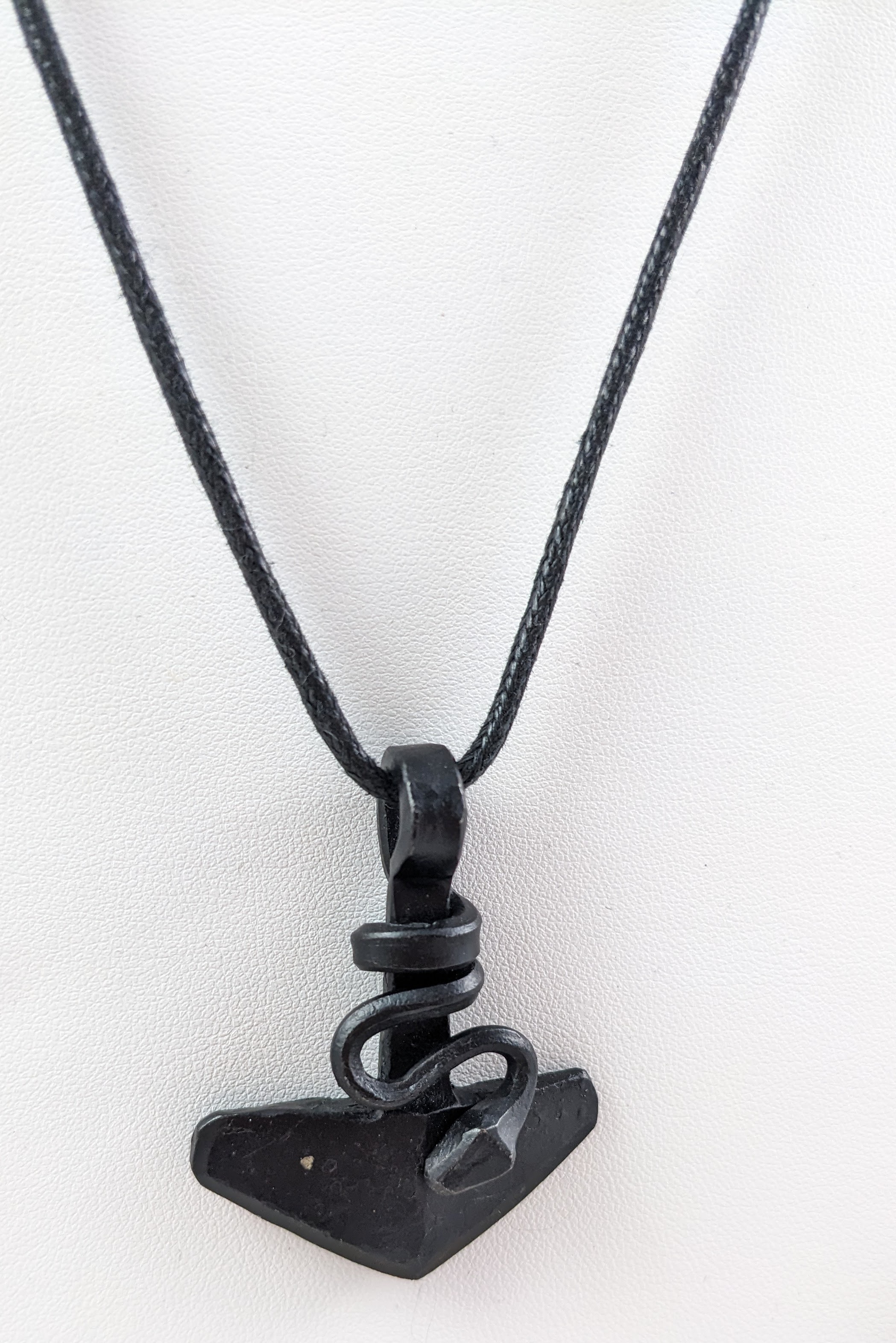 A closeup of thor's hammer with a snake wrapped around the base.