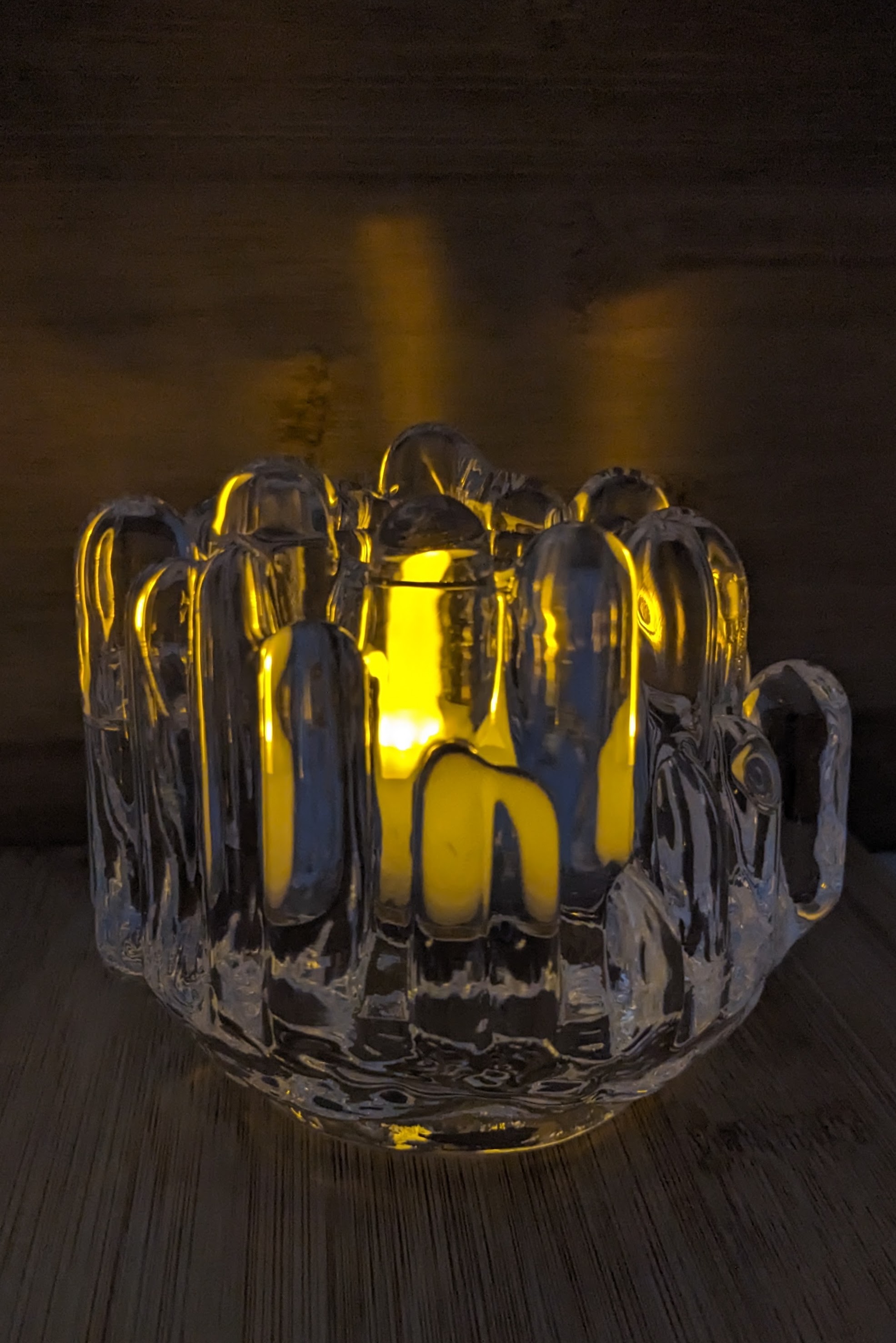 Polar crystal votive with a lit tealight in a dark room to create a serene ambiance. 