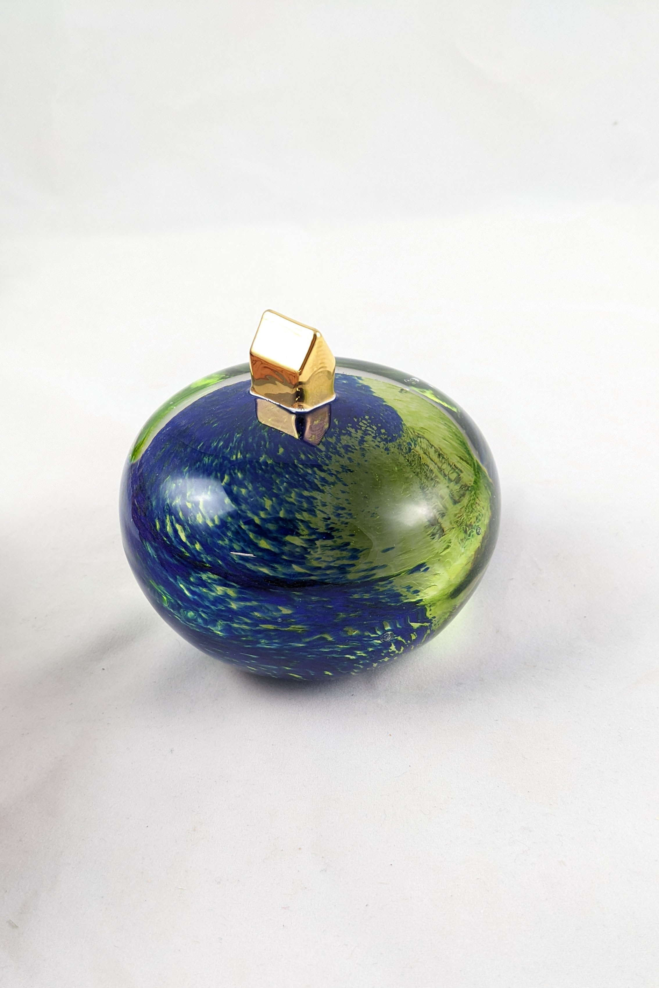 A gold plated home atop a blue and green sphere illustrating a home on earth.