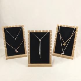 A collection of the dala horse jewelry each laid out of a black display with natural wood trim.