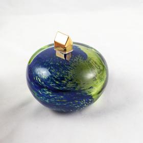 A gold plated home atop a blue and green sphere illustrating a home on earth.